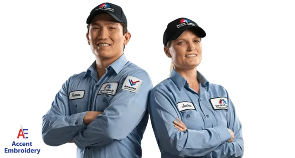 's team spirit. Two men wearing blue shirts and caps stand side by side, representing a local embroidery shop's team spirit.