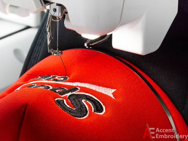 Close-up of a machine embroidering a logo on a work uniform, showing durable branding